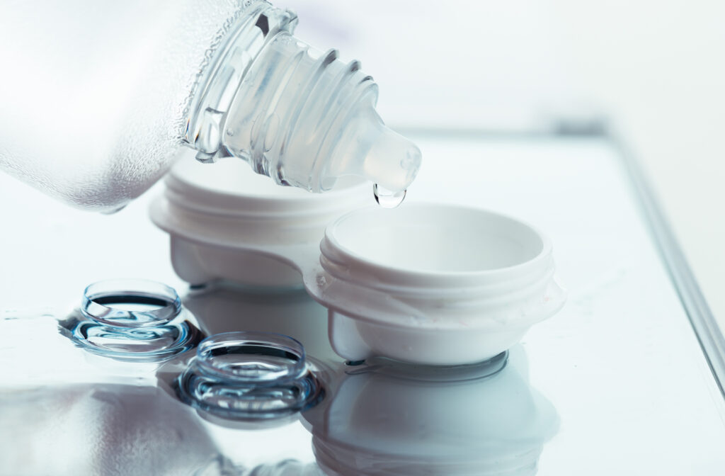 Contact lens solution being poured into case with contact lenses on table