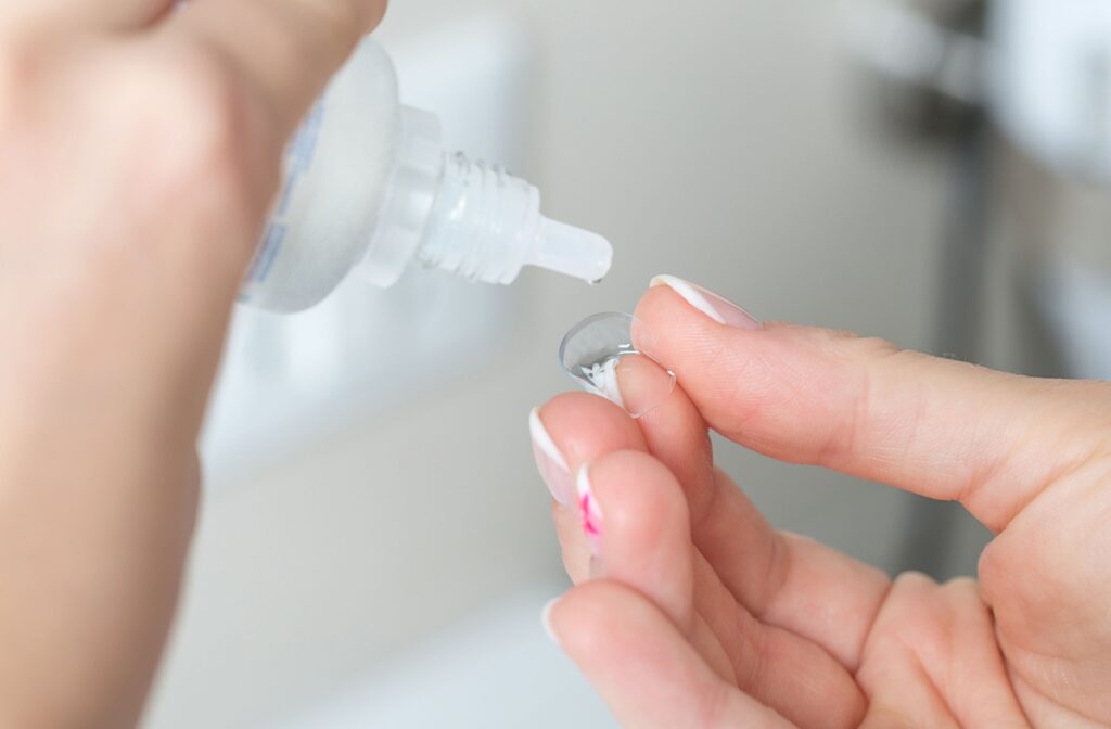 A close-up image of someone rinsing their contact lens to clean it and prevent contact lens-induced dry eye.