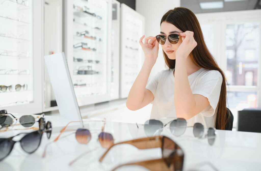 A person trying on prescription sunglasses at their optometrist's office.