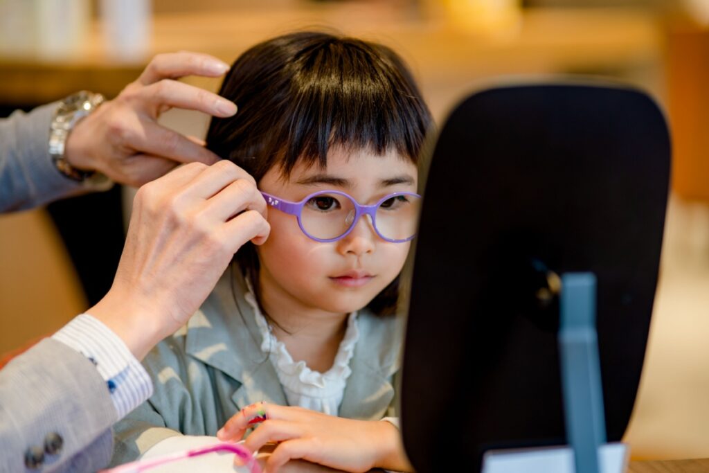 A child getting fitted for eyeglasses to correct myopia.