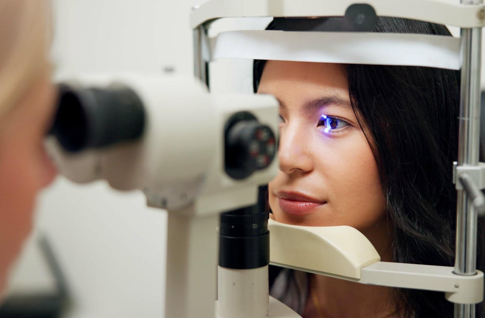 A patient with keratoconus having their eyes examined by an optometrist to determine the right correction method for them.